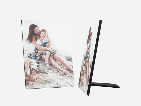 Ein Fotoaufsteller zeigt ein schönes Bild von einer jungen Frau, einem kleinen Kind und einem goldenen Retriever-Hund. Die Frau hat lange, braune Haare und trägt ein gemustertes Top und einen Rock. 